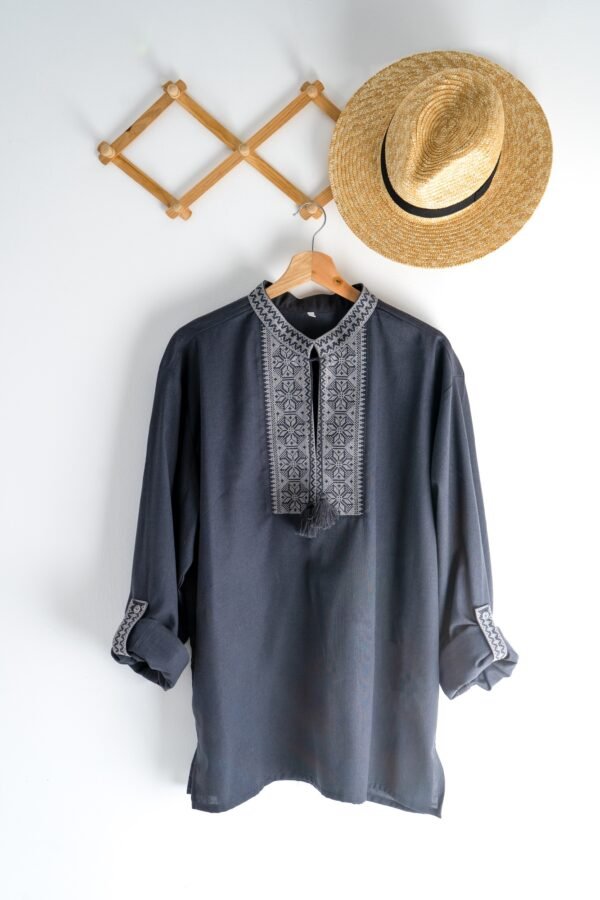 Ukrainian clothes embroidered man shirt. Blue gray and black threads background. Vyshyvanka is a